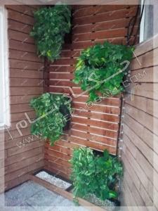 نمای تراس سبز تجریش ترکیب چوب ترمووود و گل و گیاه در گلدان دیواری