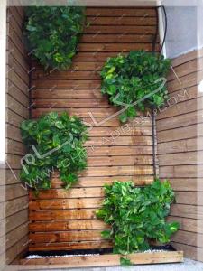 نمای تراس سبز تجریش ترکیب چوب ترمووود و گل و گیاه در گلدان دیواری